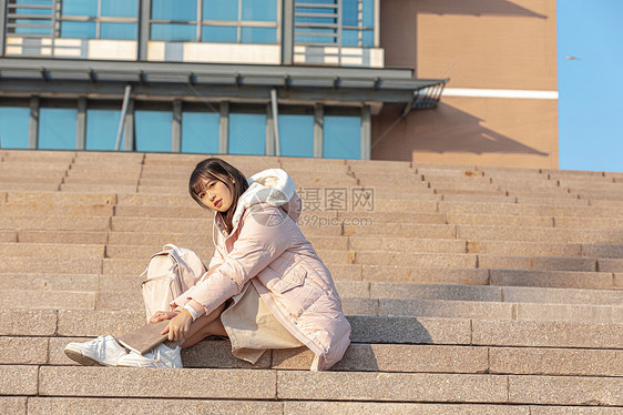 坐在户外台阶上的女大学生图片