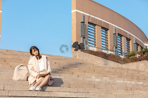 在校园台阶上看书的大学生图片