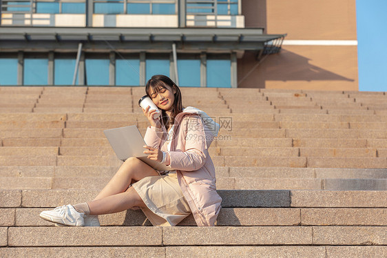 坐在学校台阶上使用电脑的女同学图片