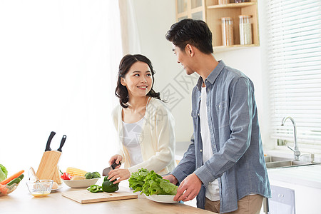 家庭烹饪年轻夫妻在厨房一起备菜背景