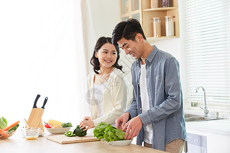 年轻夫妻在厨房一起备菜图片