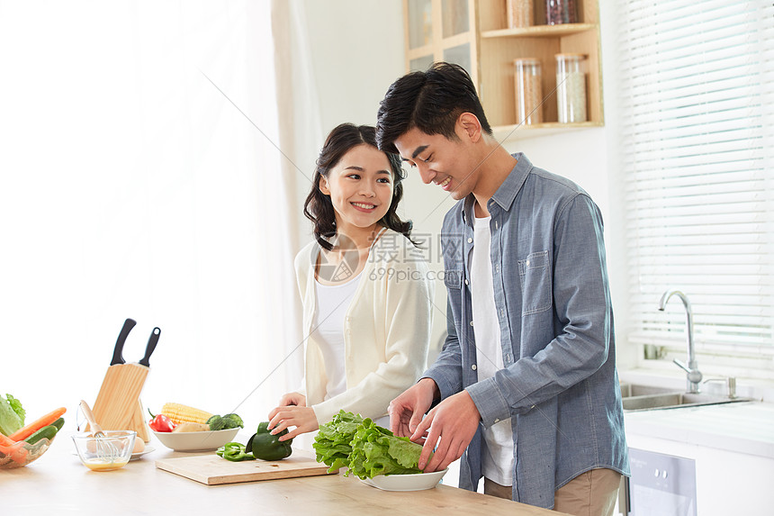 年轻夫妻在厨房一起备菜图片