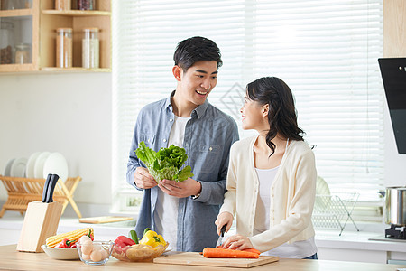 年轻夫妻在厨房一起备菜图片