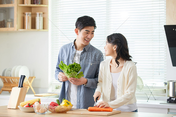 年轻夫妻在厨房一起备菜图片