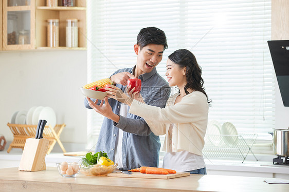 年轻夫妻在厨房一起备菜图片