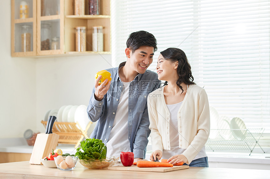 年轻夫妻在厨房一起备菜图片