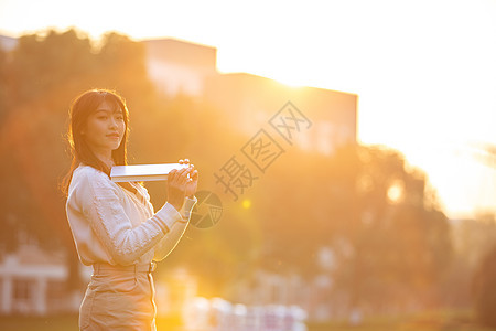 夕阳下活泼的女大学生图片