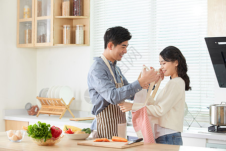 年轻男士给妻子系戴围裙图片