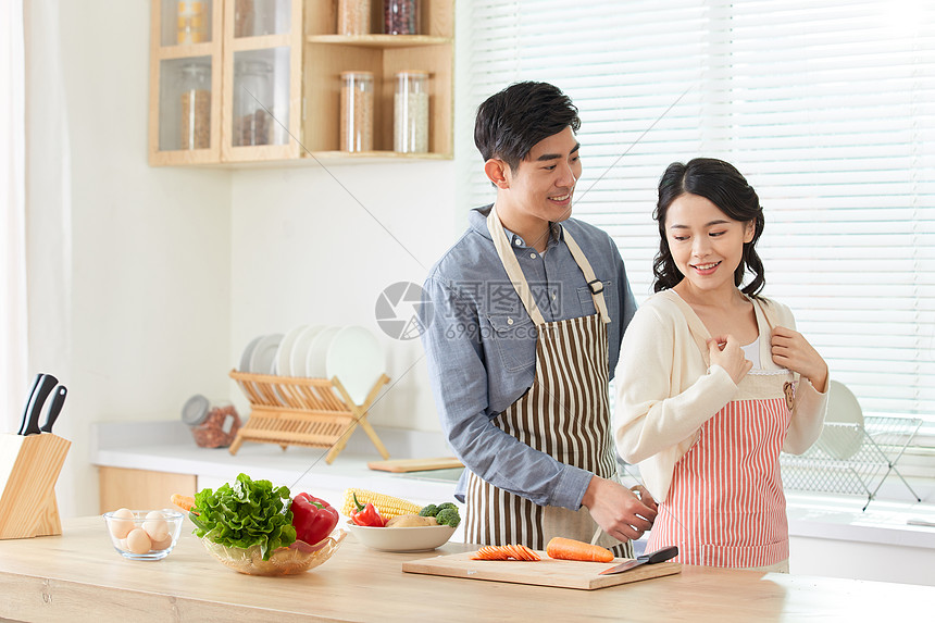 年轻男士给妻子系戴围裙图片