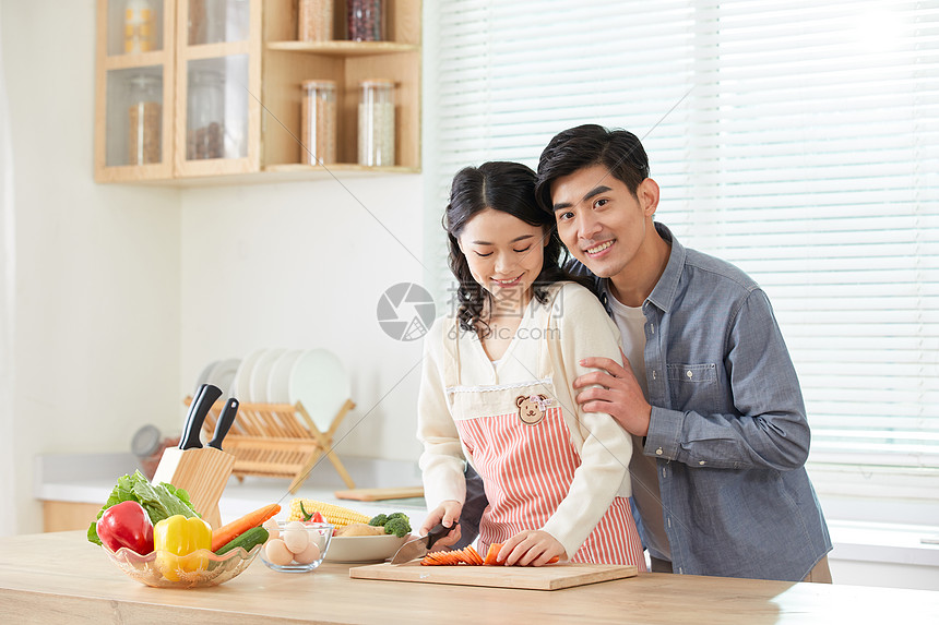 年轻夫妻在厨房甜蜜互动图片