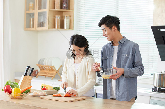 年轻夫妻在厨房甜蜜互动图片