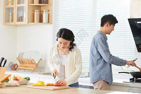 年轻夫妻在厨房一起做菜高清图片