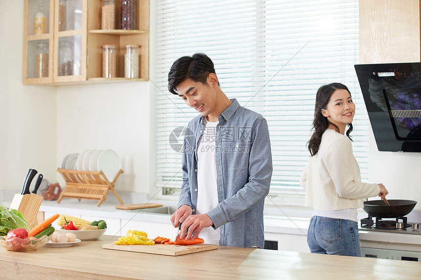 年轻夫妻在厨房一起做菜图片