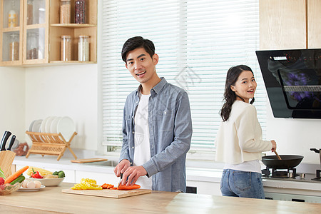年轻夫妻在厨房一起做菜图片