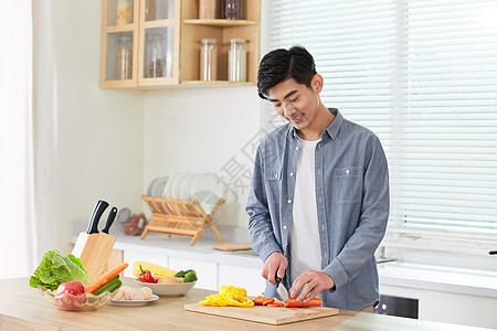 家庭健康年轻男士在厨房切菜背景