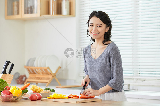 年轻女士在厨房切菜图片