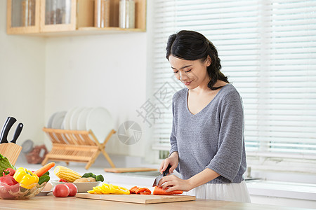 年轻女士在厨房切菜图片