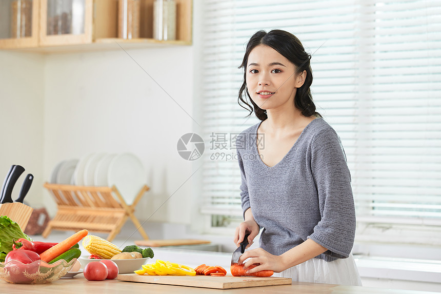 年轻女士在厨房切菜图片