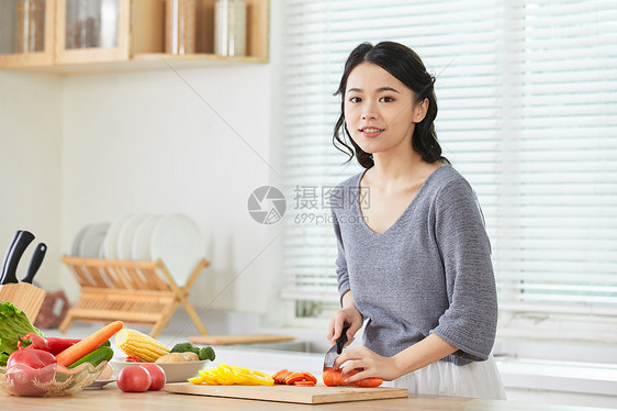 年轻女士在厨房切菜图片