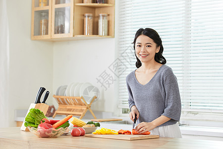 年轻女士在厨房切菜图片