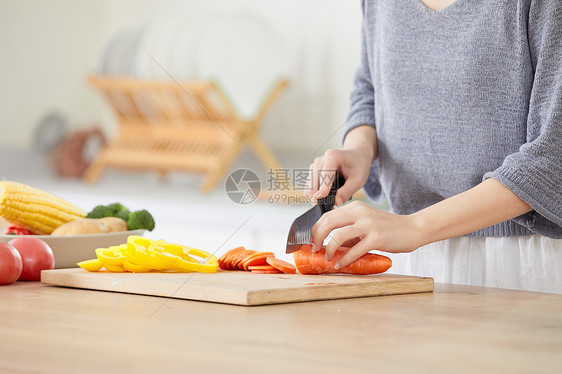 年轻女士在厨房切菜特写图片