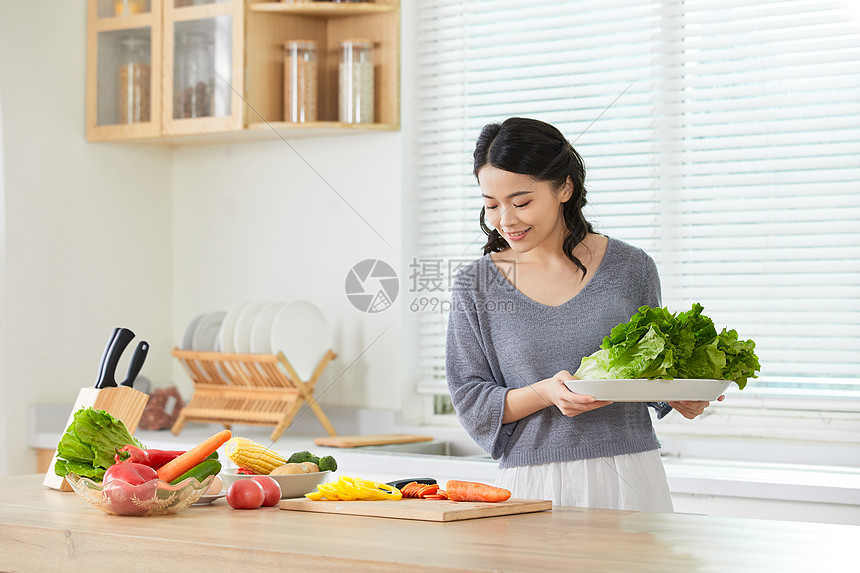 年轻女士在厨房备菜图片