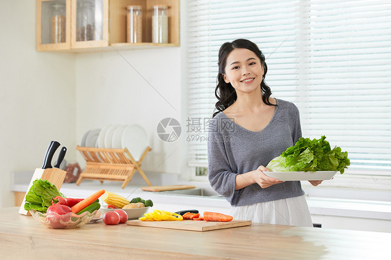 年轻女士在厨房备菜图片