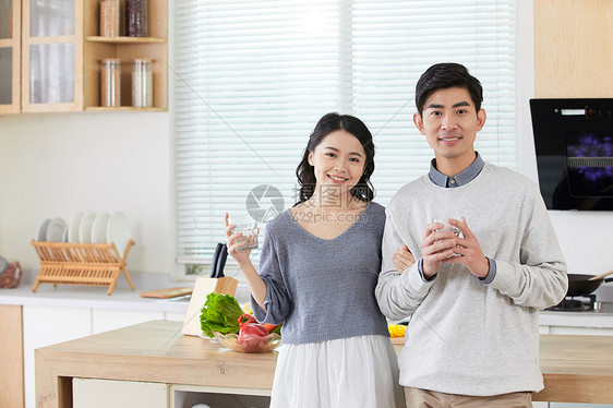 年轻情侣在厨房拿水杯图片