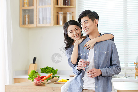 年轻情侣在厨房拿水杯喝水背景图片