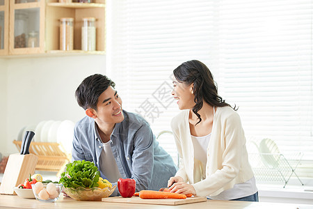 年轻情侣在厨房甜蜜对视图片
