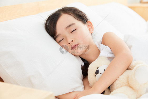 小女孩躺在床上睡觉图片