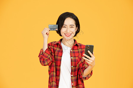 青年女性刷信用卡手机网购图片