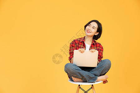年轻女性坐椅子上网购消费背景图片