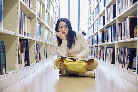 女学生在图书馆看书思考图片