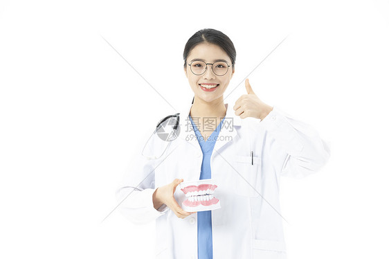 女性牙医拿着假牙点赞图片