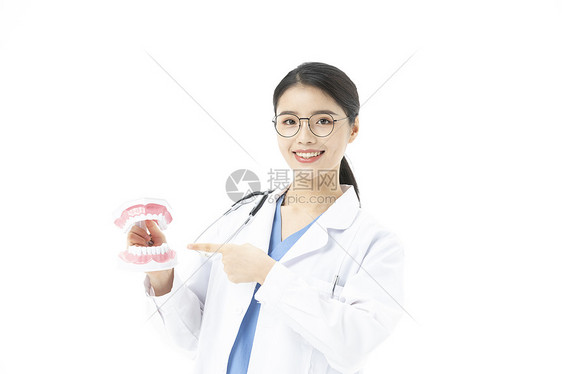 女性牙医拿着假牙讲解牙齿健康图片