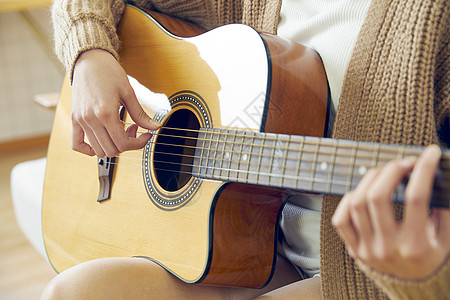 背着吉他文艺美女在家弹吉他背景