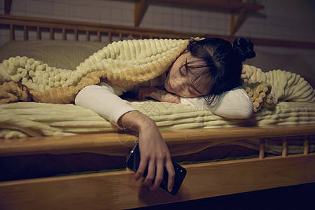 年轻女性在家熬夜玩手机睡着图片