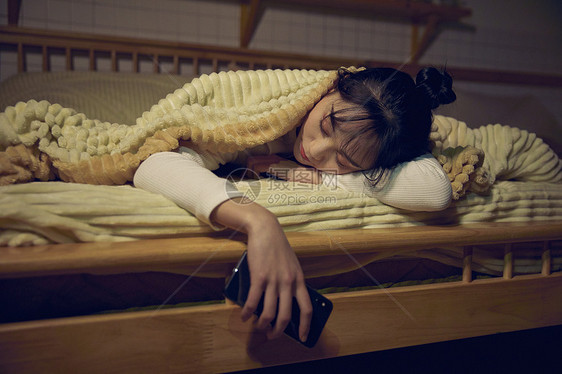 年轻女性在家熬夜玩手机睡着图片
