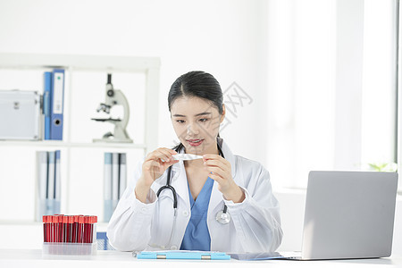 女性医生拿着电子体温计观察图片
