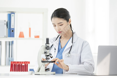 女性医生显微镜观察血液试剂背景图片