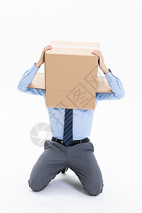 跪在地上头上套纸盒箱的绝望商务男性背景图片