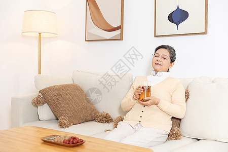 老奶奶坐沙发上喝茶颈部按摩图片