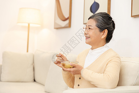 老奶奶坐沙发上喝银耳汤图片