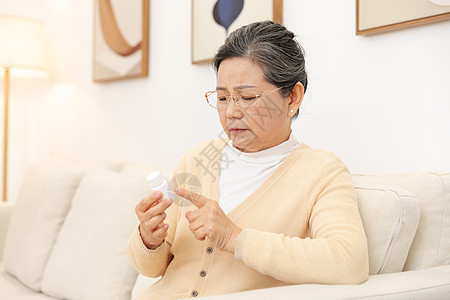 老奶奶坐沙发上看药品说明图片