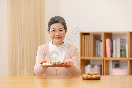 健康老人老奶奶居家养生手捧银耳汤食材背景