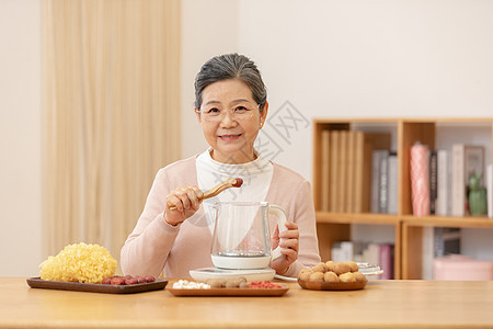 老奶奶居家养生煮银耳汤夹红枣背景图片