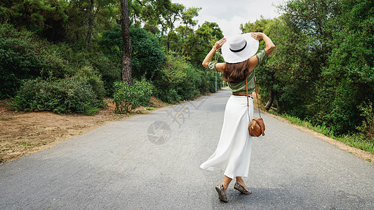 土耳其绿茵小路森林中旅行路上少女背影背景图片