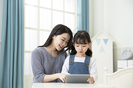 亲子课堂妈妈指导女儿用平板电脑在家上课背景