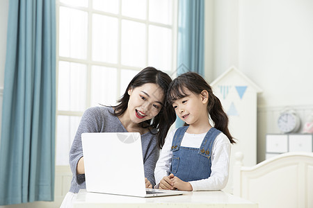 靠着母亲女儿母女在家笔记本电脑上网课背景
